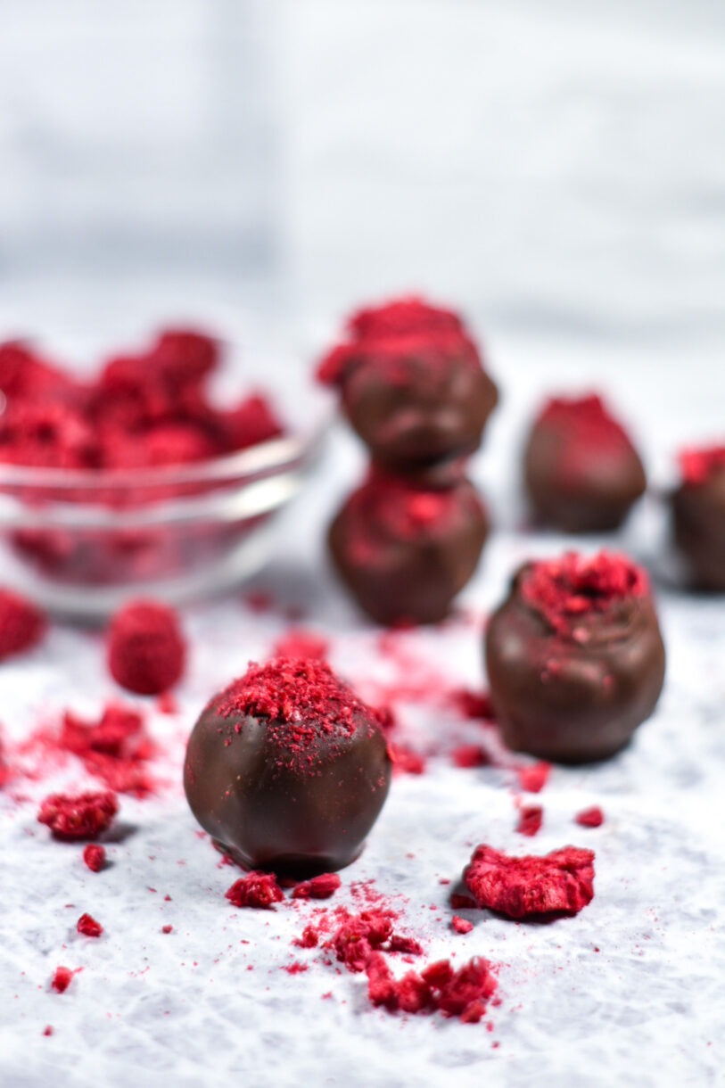 Valentine's Day chocolate raspberry truffles arranged on a white surface