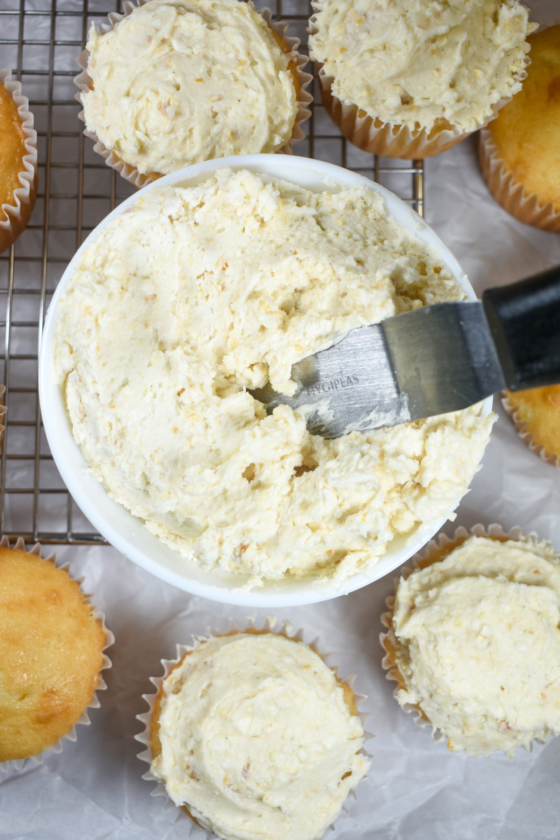 a bowl of caramel popcorn buttercream surrounded by cupcakes