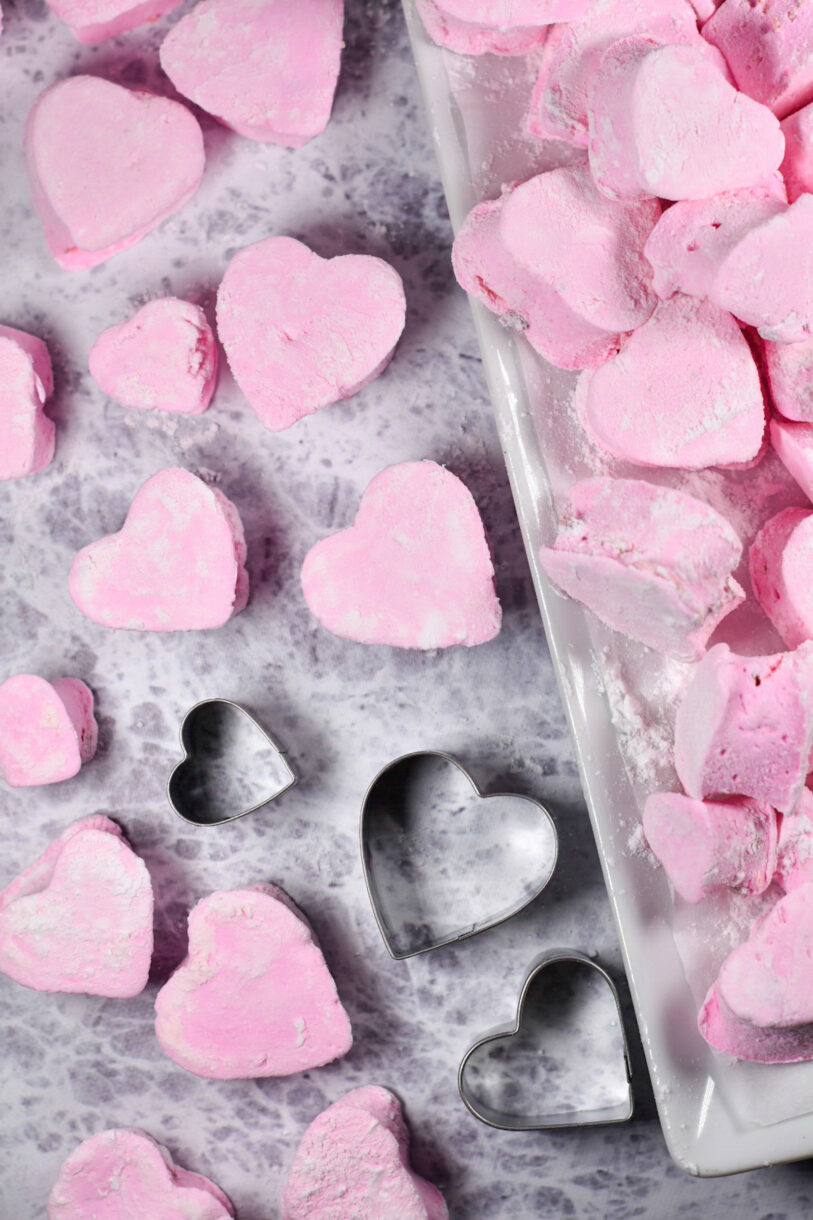Pink heart marshmallows arranged on a grey surface