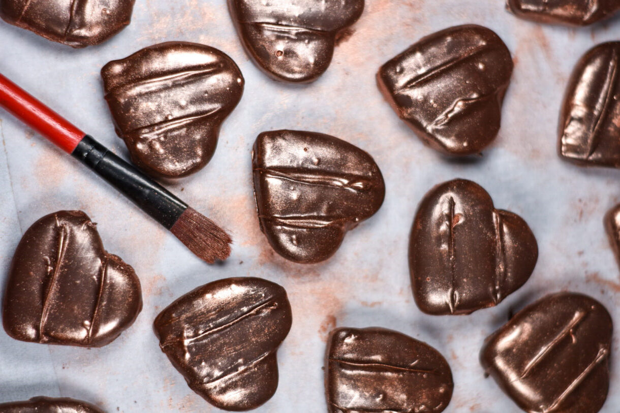 Heart shaped chocolate peppermint patties and a paintbrush, on a white surface