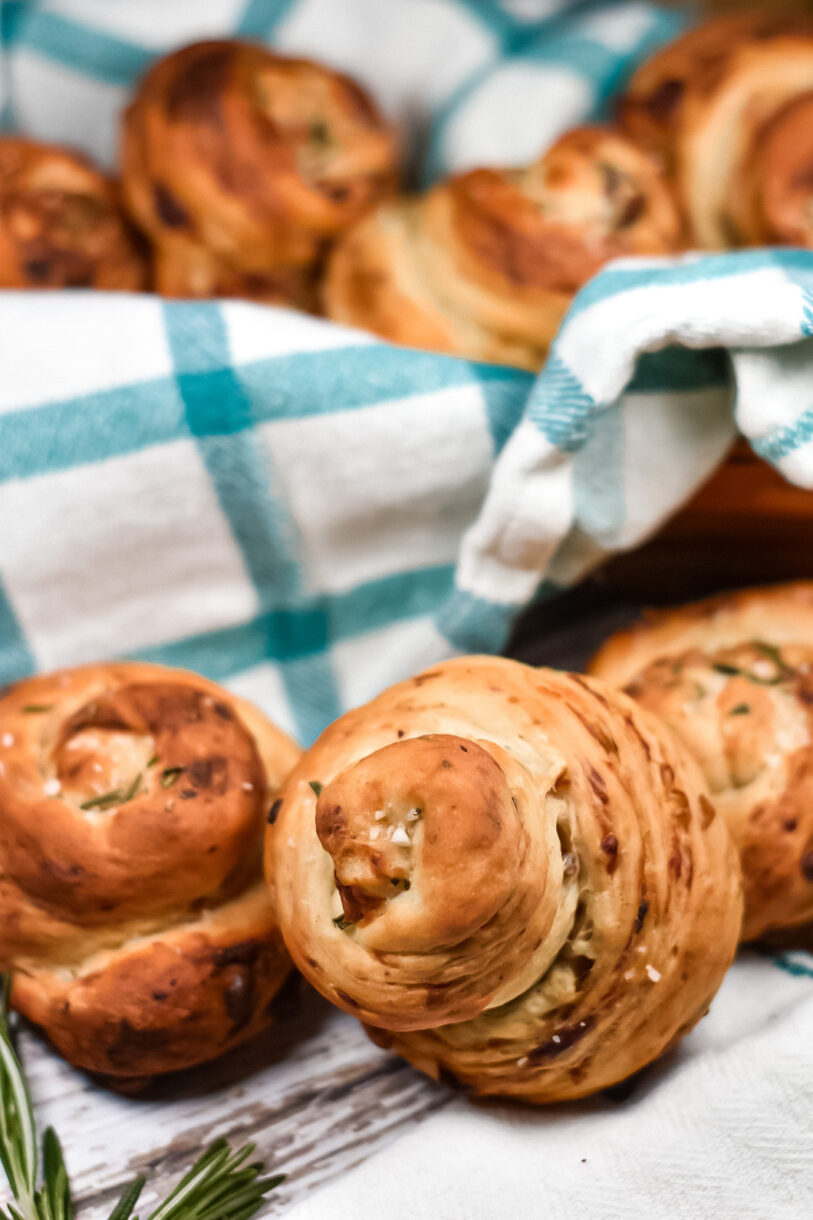 Bleu cheese, date, and rosemary bread rolls wrapped in a plaid tea towel