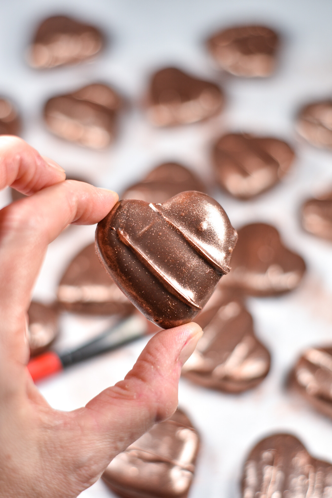 hand holding a heart shaped chocolate peppermint patty