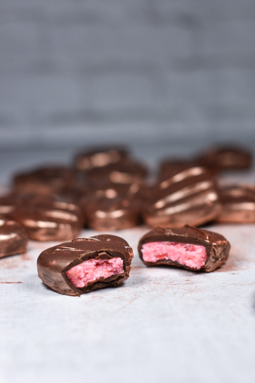 Two strawberry peppermint patties with a bite missing from each