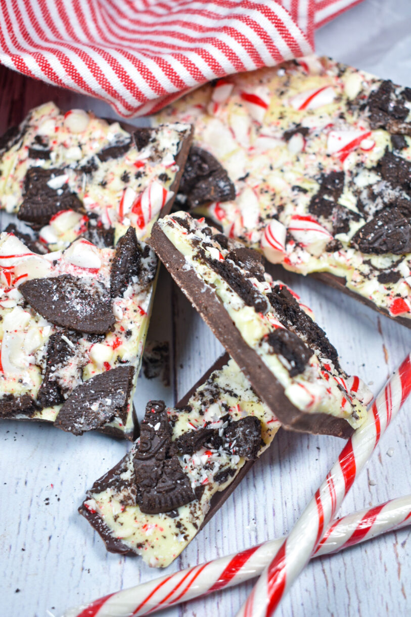 Peppermint bark and candy canes on a white surface