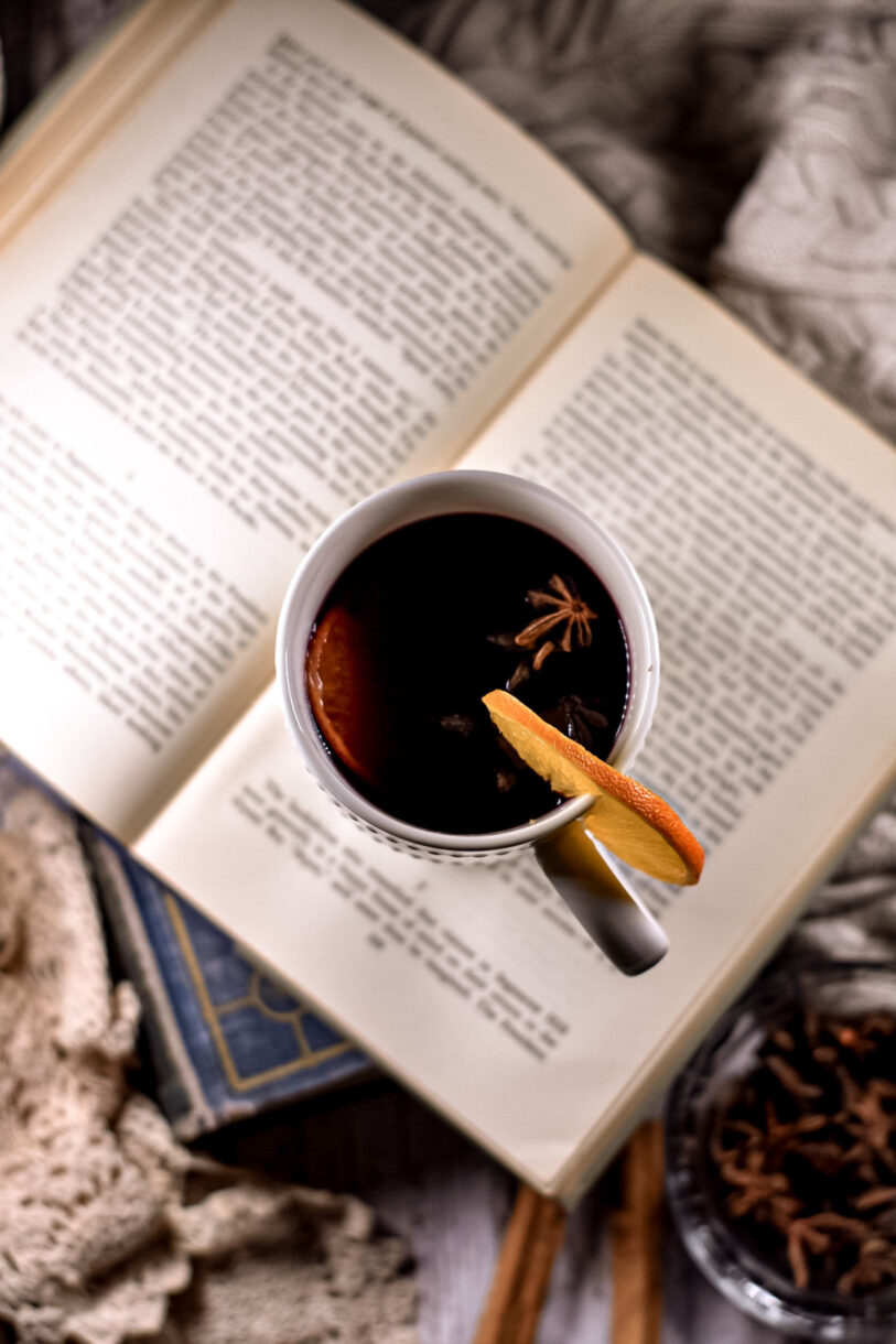Mulled wine in a mug, sitting on top of an open book
