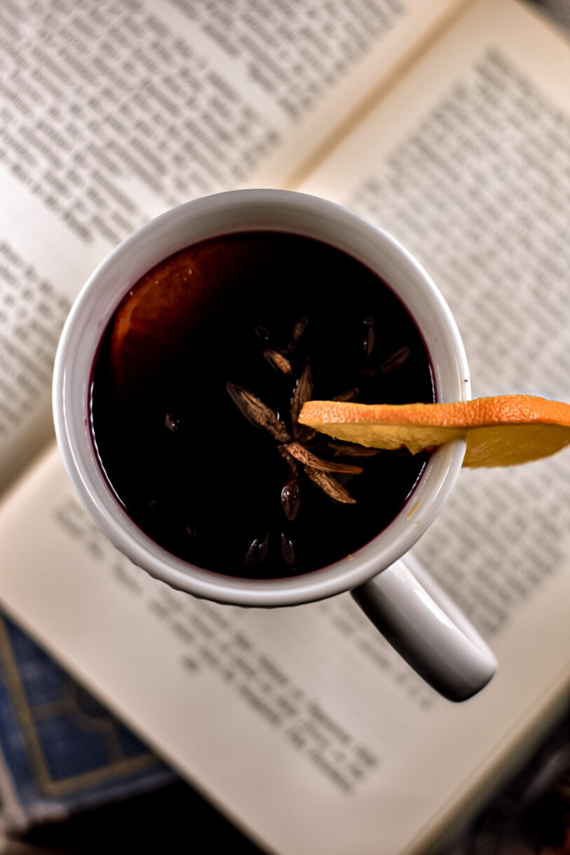 Closeup shot of a mug of mulled red wine garnished with oranges and star anise