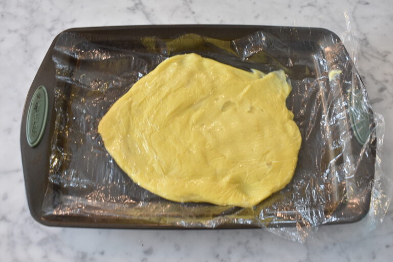 Pastry cream covered with clingfilm on tray