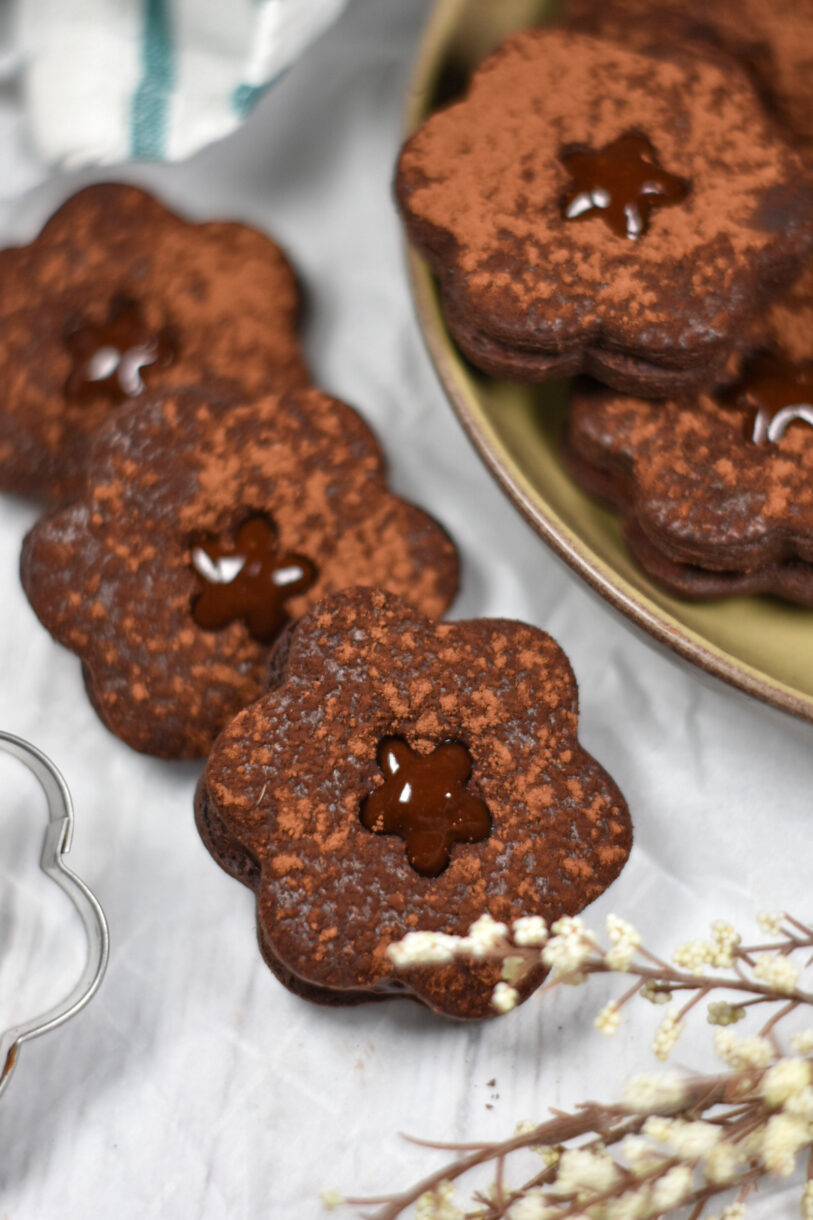 Flower shaped chocolate sandwich cookies on a white surface