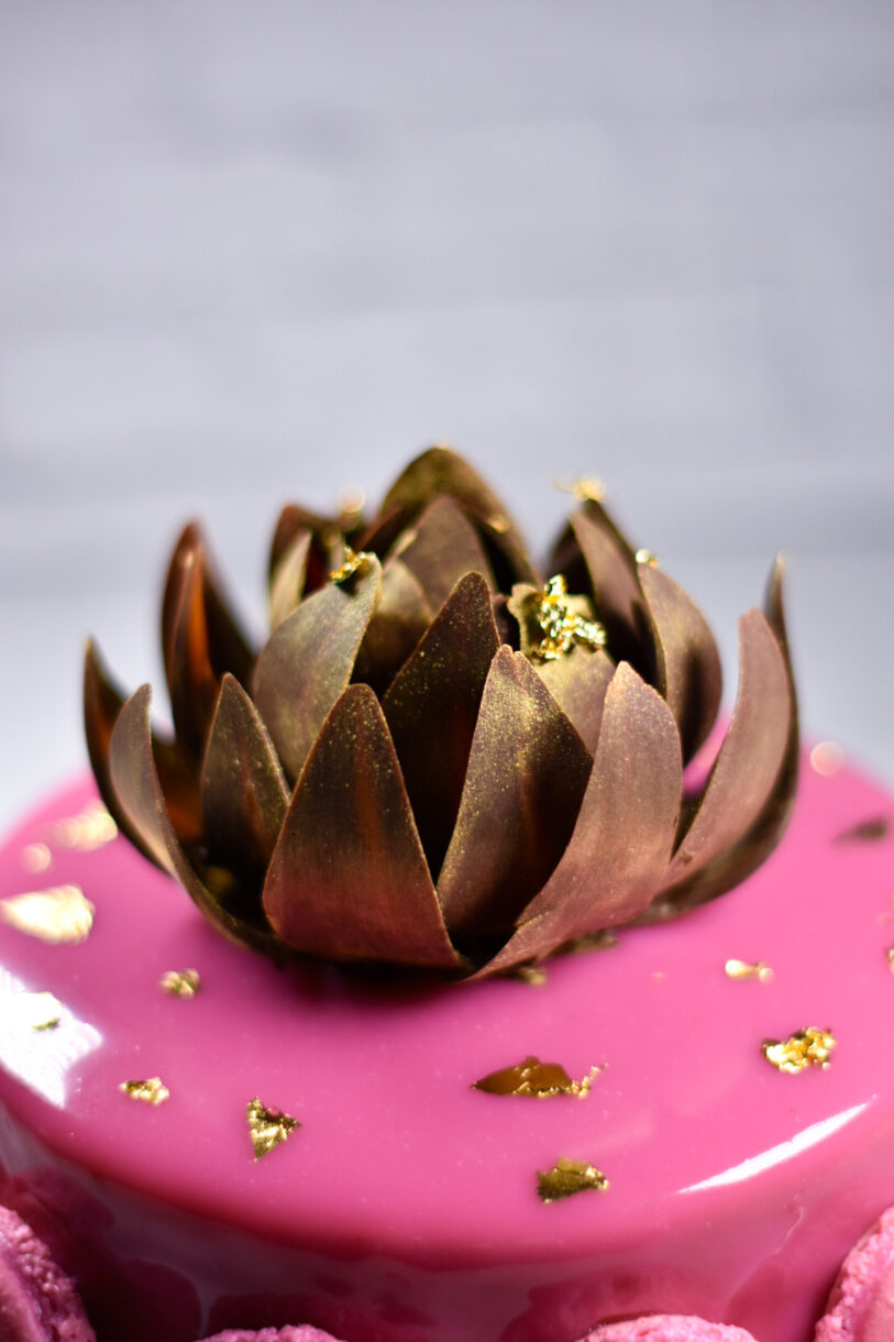 Passionfruit, coffee, and chocolate entremet with gold chocolate rose on top