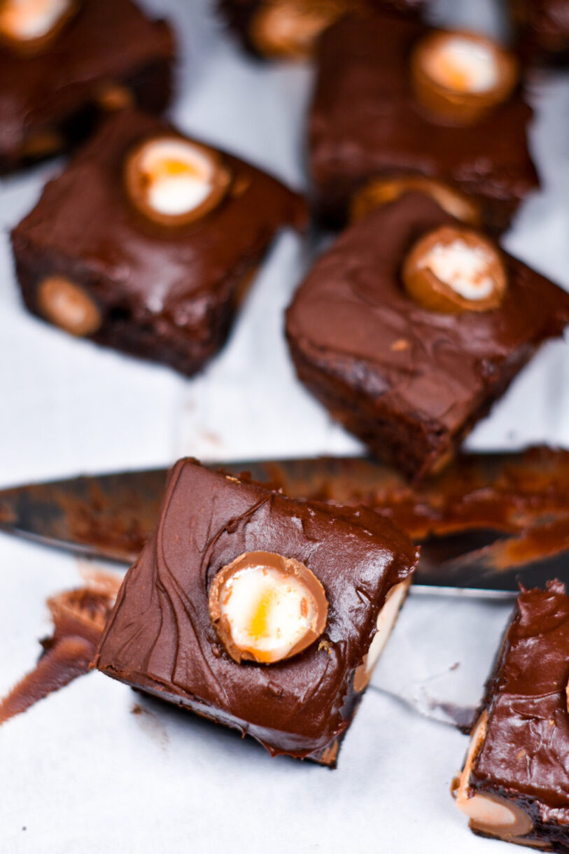 Brownies made with Cadbury creme eggs and chocolate frosting, with a frosting-covered chef's knife