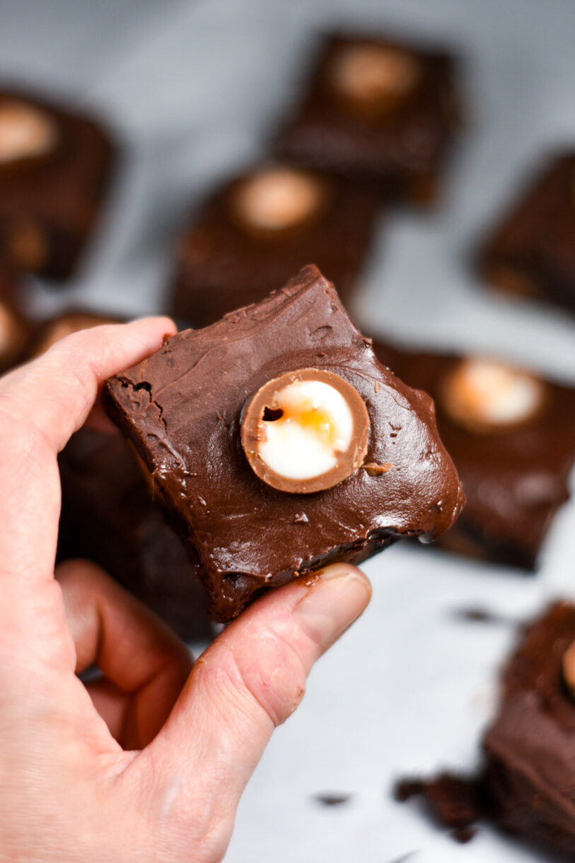 Hand holding a creme egg brownie square