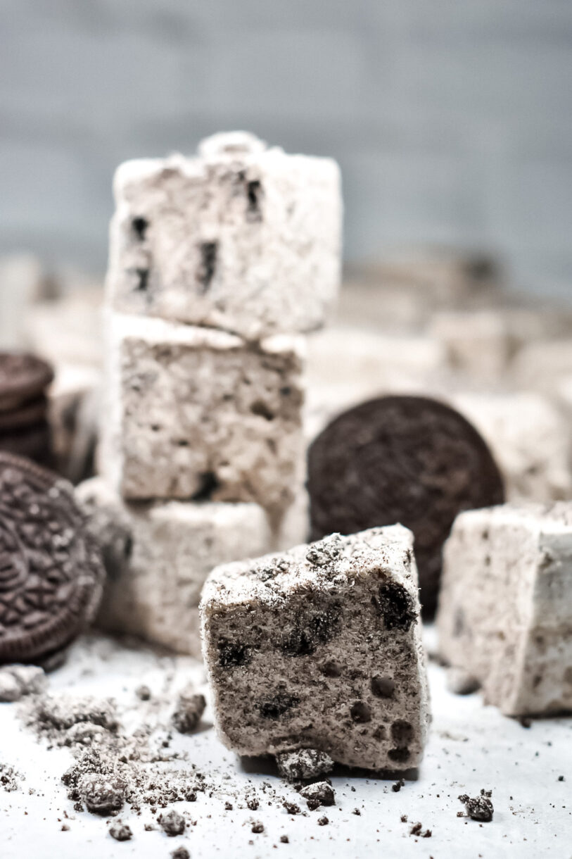 Oreo marshmallows and Oreo cookies scattered on a white background