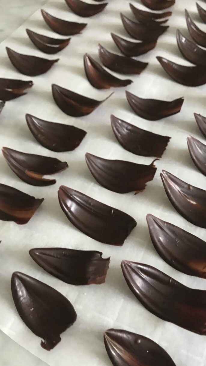 Tempered chocolate petals arranged on a sheet of parchment