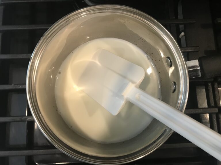 Milk in a metal saucepan, with spatula