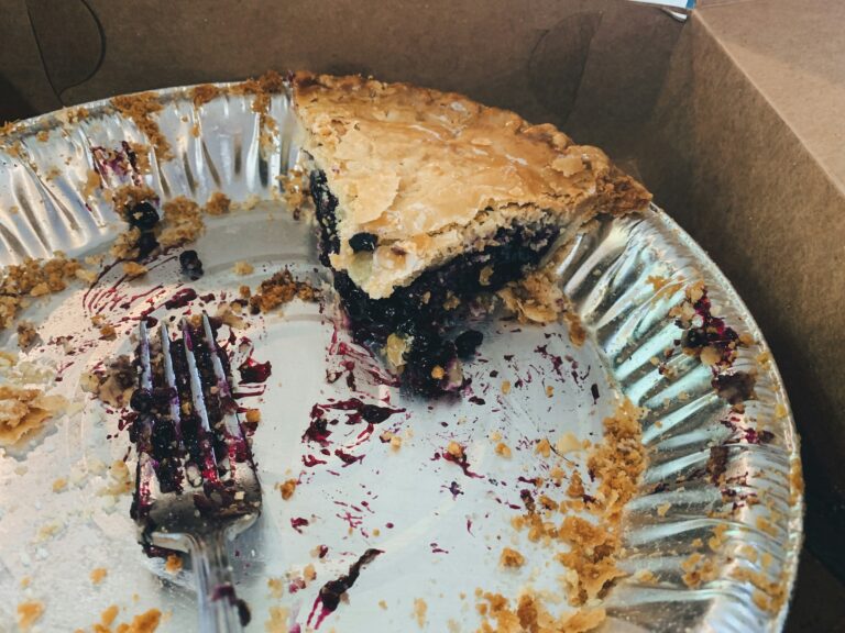 A pie tin with one slice of blueberry pie