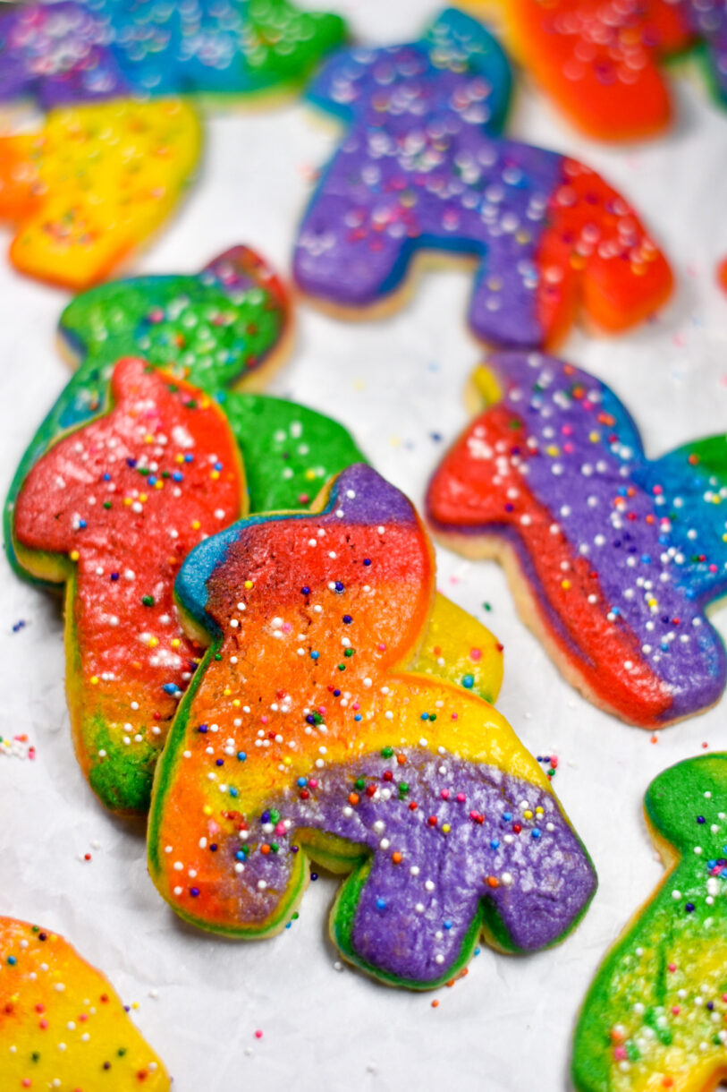 A stack of rainbow donkey pinata cookies on a white background