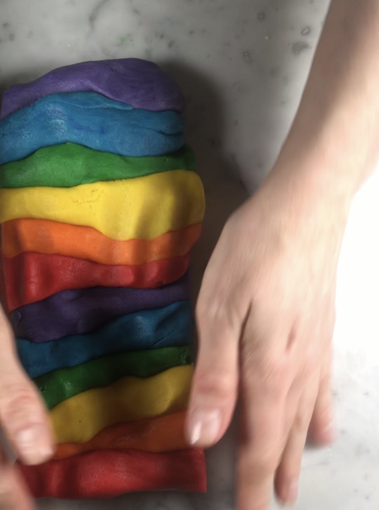 Shaping rainbow cookie dough with hands