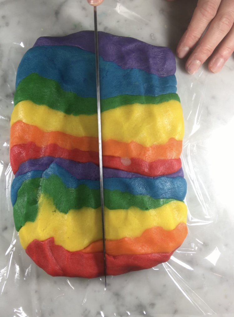 Cutting rainbow cookie dough with a knife