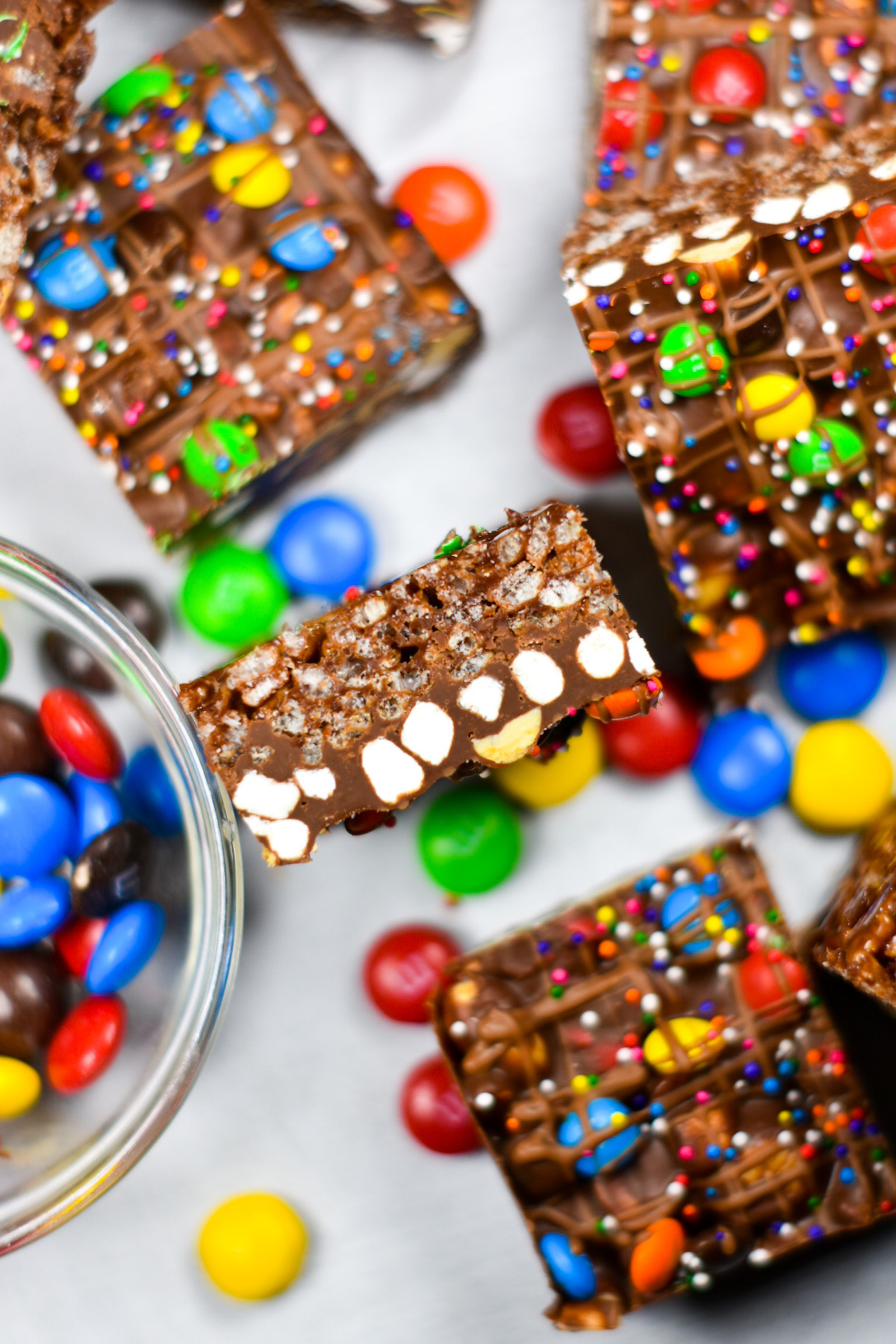 rainbow rocky road slices arranged on a white surface with M&M candies