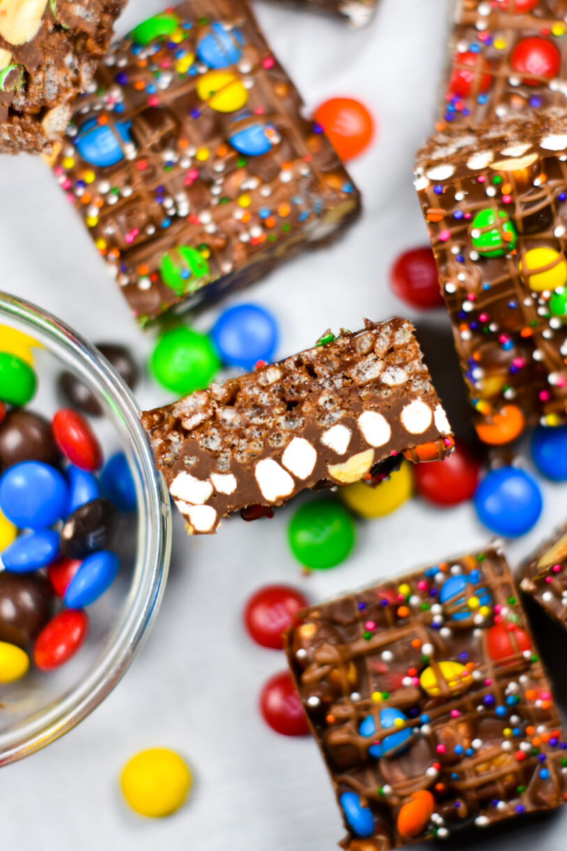 Slices of rainbow rocky road and M&Ms on a white background