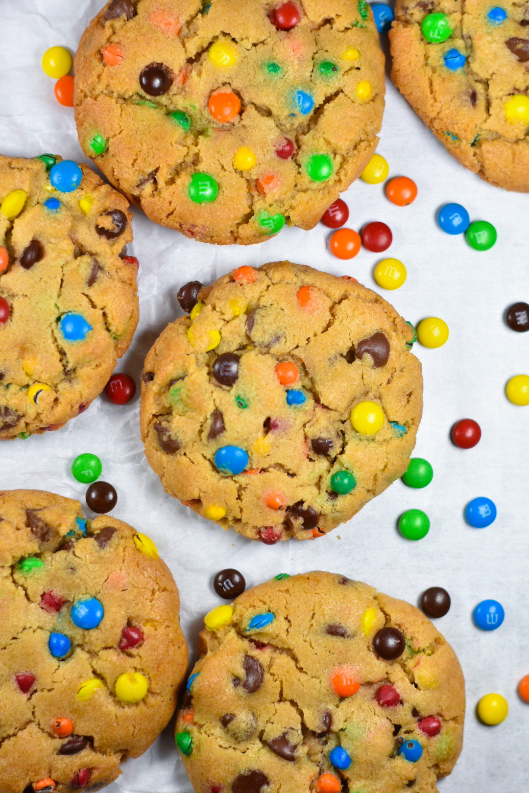 peanut butter cookies and M&Ms arranged on a white surface