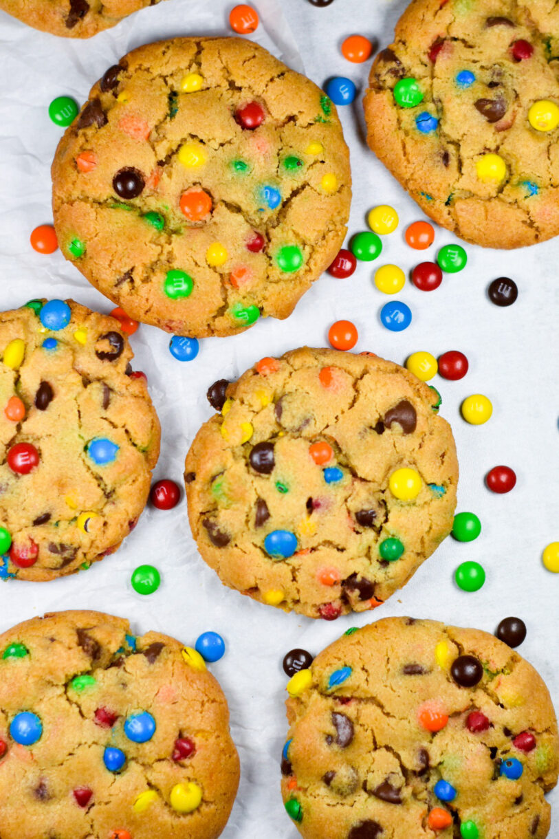 Rainbow M&M Peanut Butter Cookies on a white background, with M&M candies scattered around