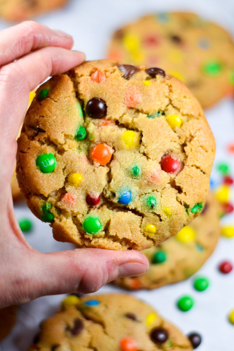 Hand holding a rainbow M&M cookie