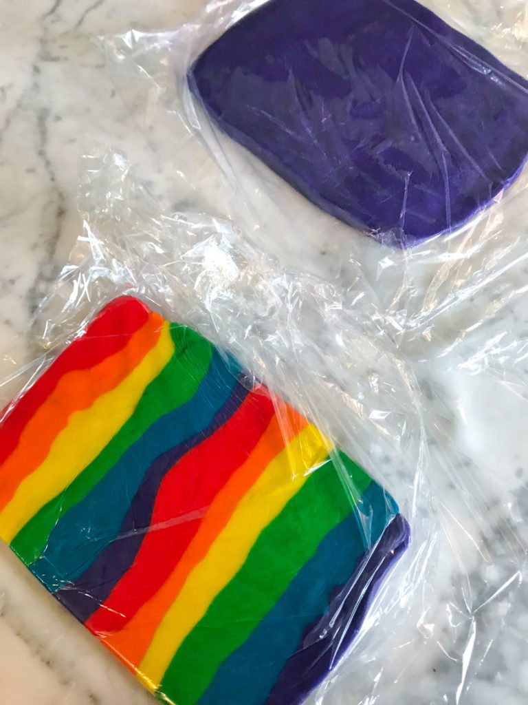 Rainbow cookie dough and purple dough wrapped in clingfilm