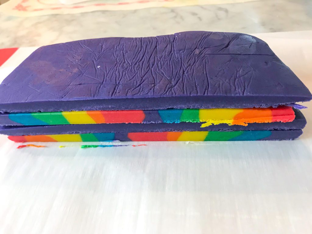 A stack of purple cookie dough and rainbow cookie dough