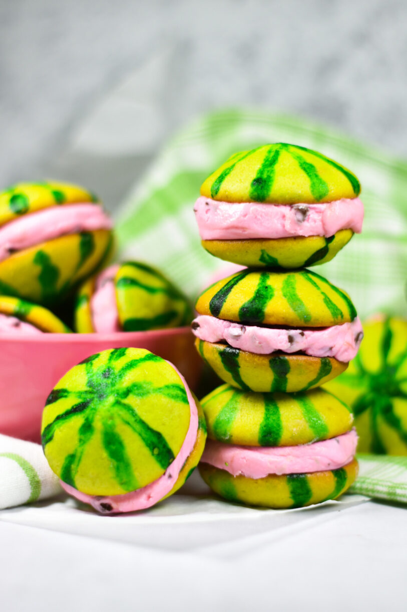 Stack of watermelon whoopie pies with a pink bowl in the background