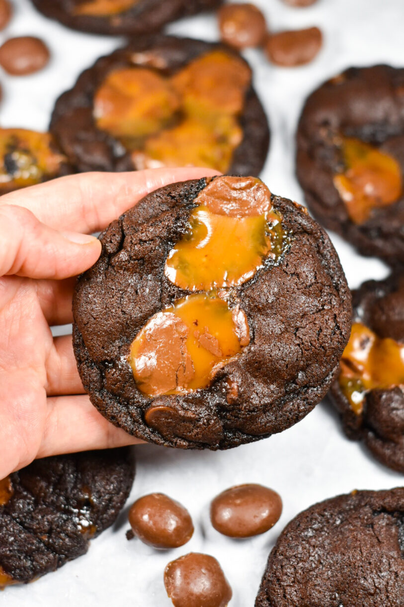 Hand holding a chocolate and caramel cookie