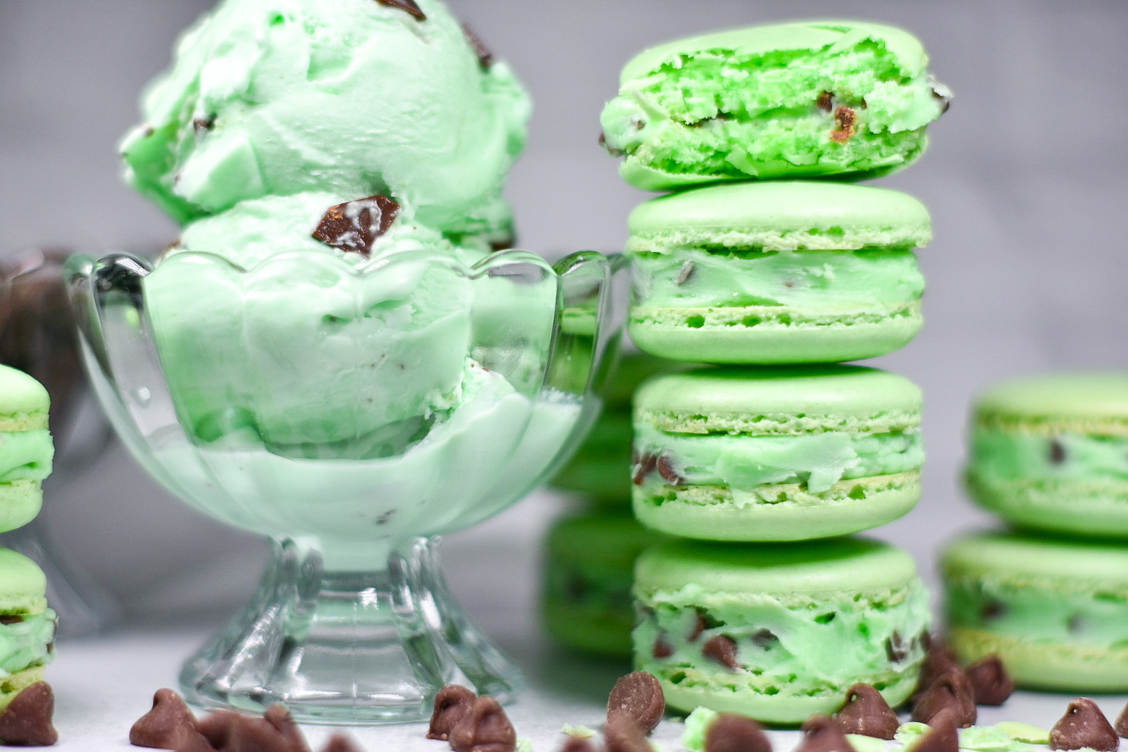 a bowl of mint chocolate chip ice cream and a stack of macarons