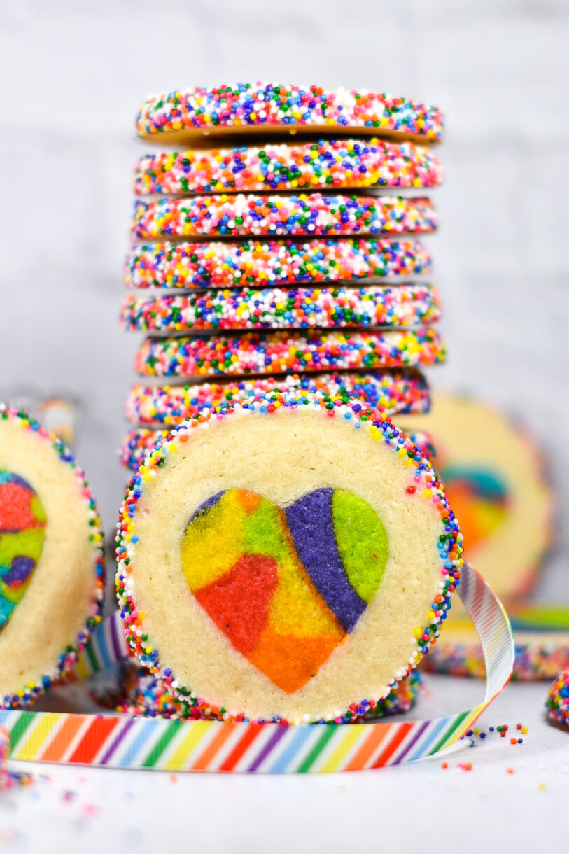 Rainbow heart cookie with a tall stack of cookies in the background