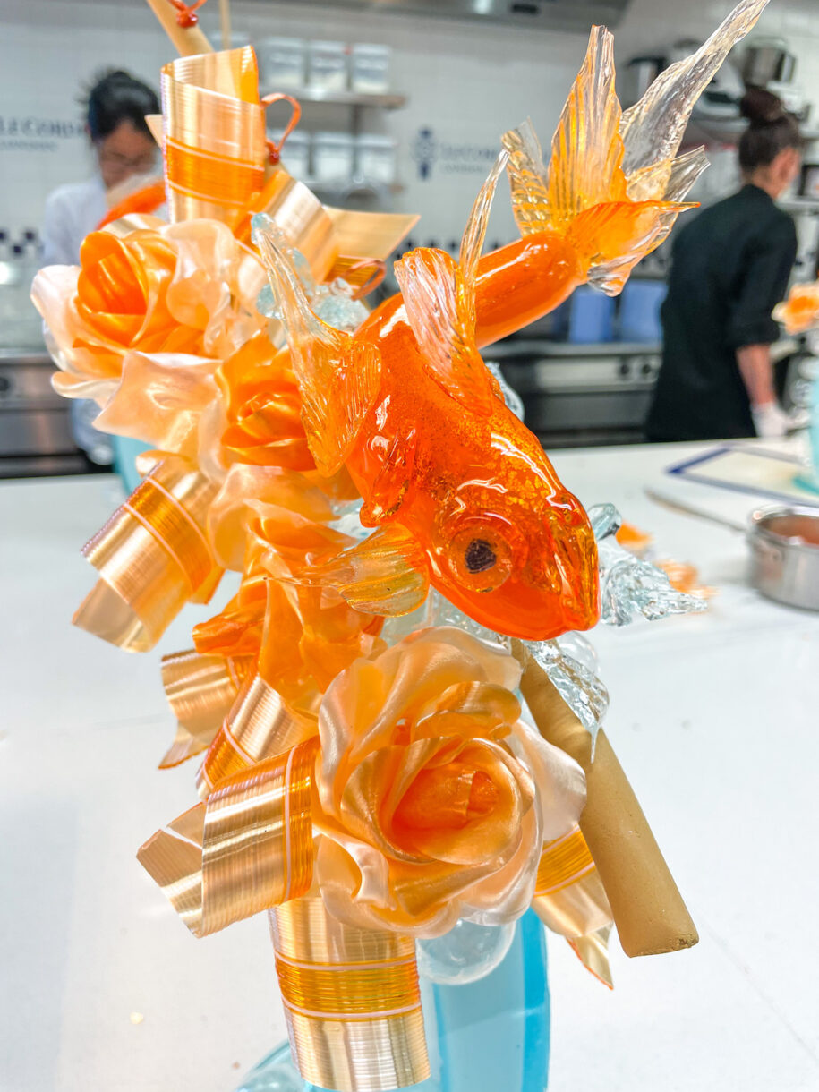 A goldfish themed sugar sculpture made of orange and blue pulled sugar