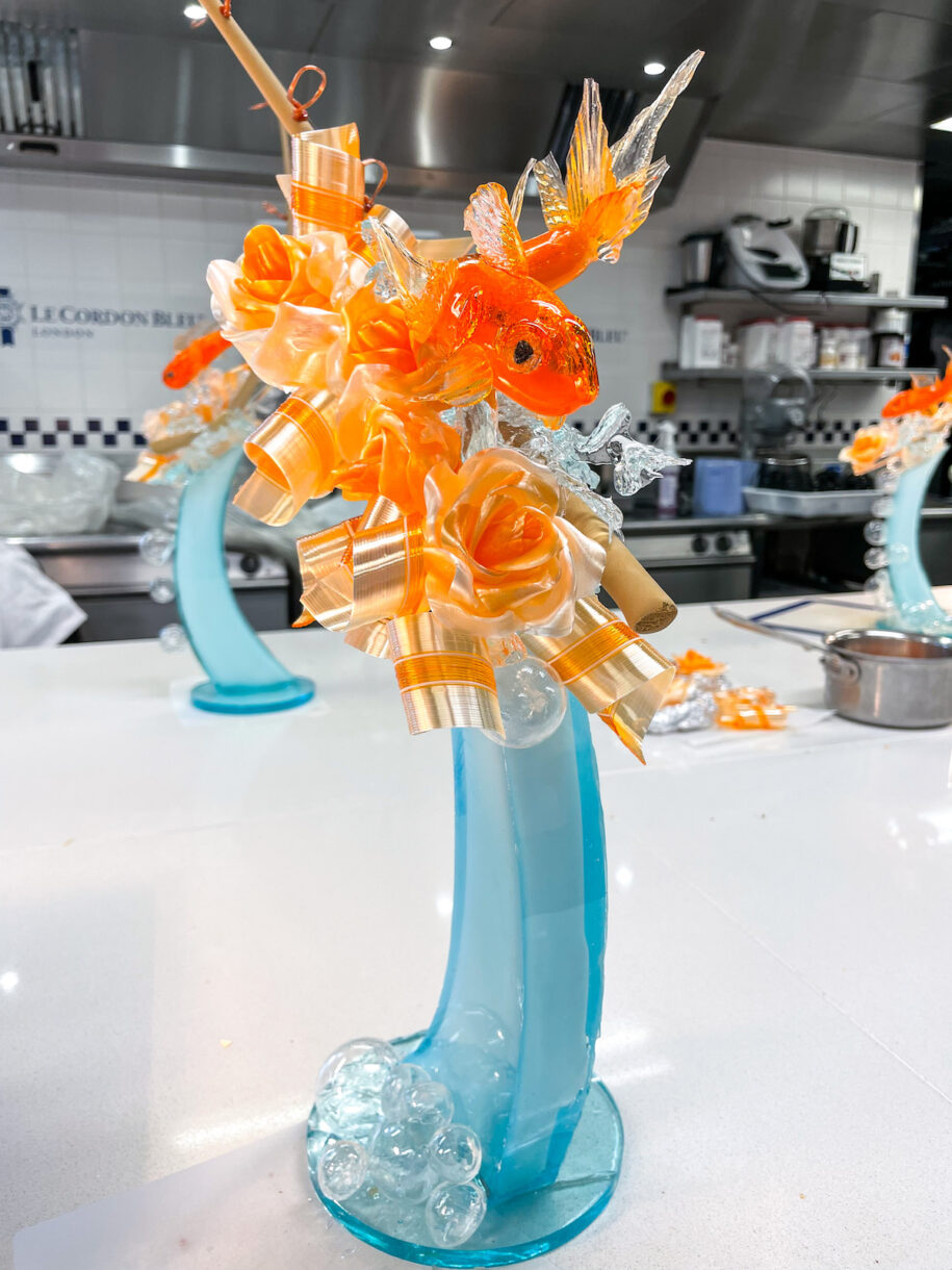 A sculpture of a goldfish, adorned by sugar ribbons and roses