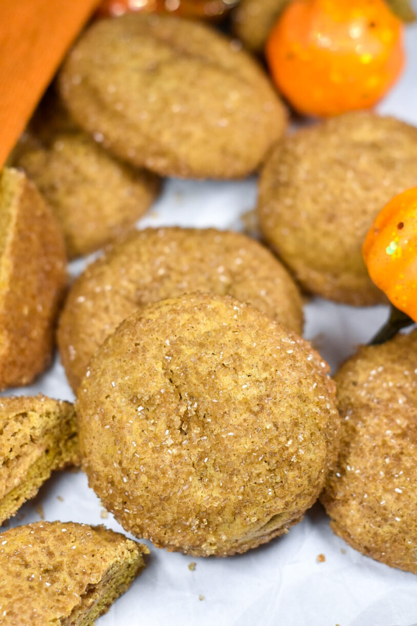 A closeup shot of a spiced pumpkin cream cheese cookie, with other cookies scattered in the background