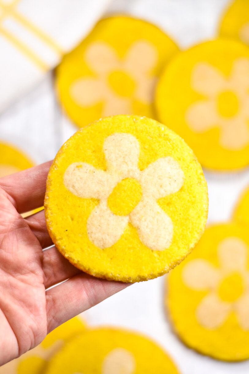 Hand holding a yellow and white slice and bake cookie