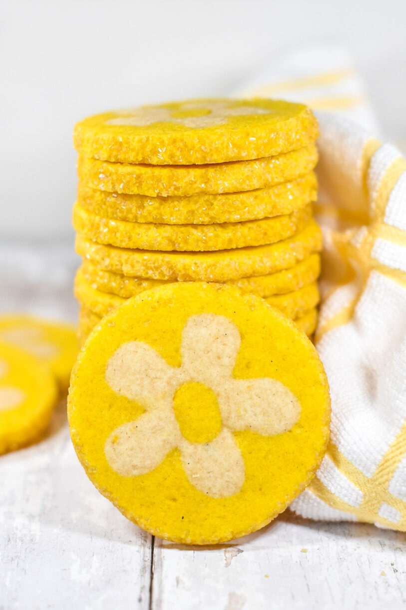 Sunny lemon daisy cookies in a tall stack, with a single cookie positioned in front