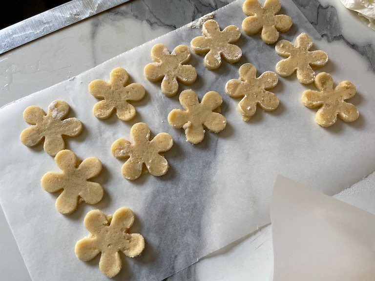 Flowers cut out of white cookie dough