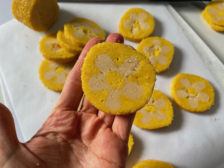 Hand holding a daisy cookie slice