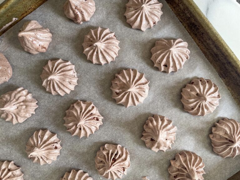 Chocolate meringues piped on a tray