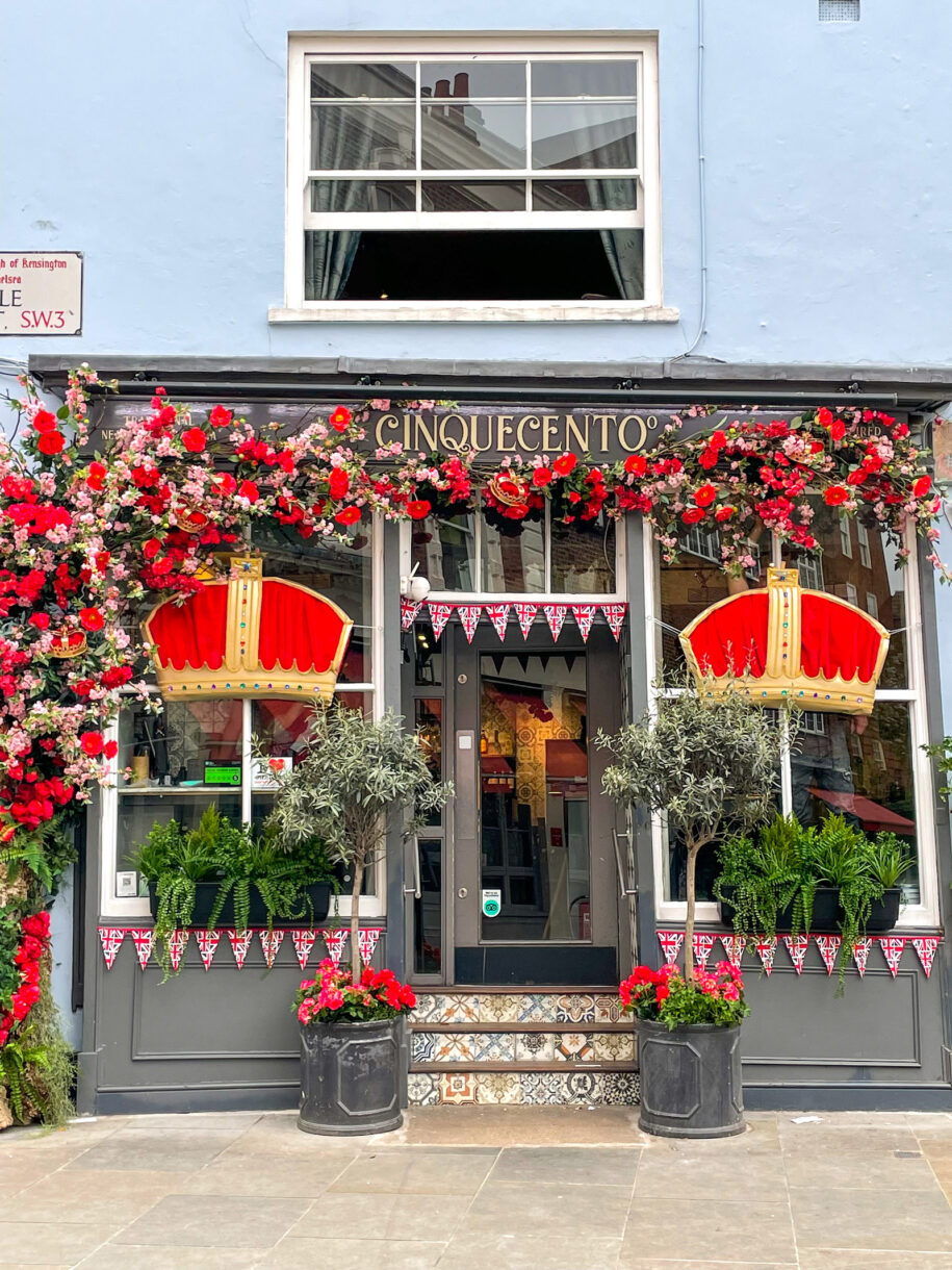 Coronation decorations in London, with red crowns adorning the windows of a Mexican restaurant