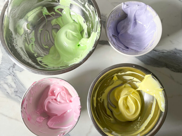 Bowls of green, purple, pink and yellow meringue to make a meringue cookies recipe
