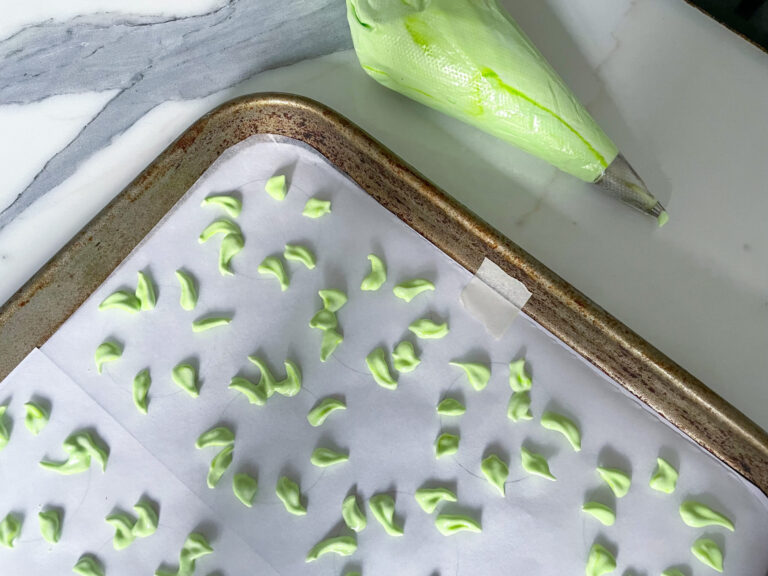 Piping green meringue onto a tray to make this meringue cookies recipe