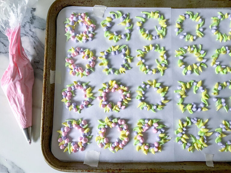 Piping floral wreath meringue cookies recipe on a parchment lined tray