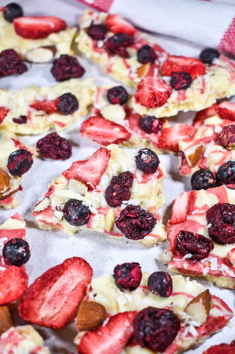 Closeup shot of broken pieces of white chocolate bark with berries and cherries and nuts