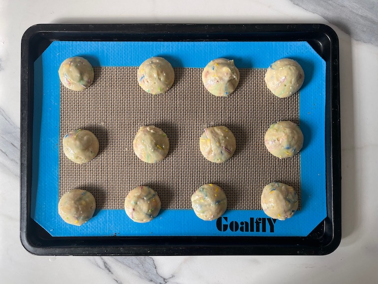 Rainbow whoopie pie batter piped on a tray