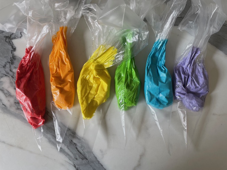 piping bags of rainbow buttercream