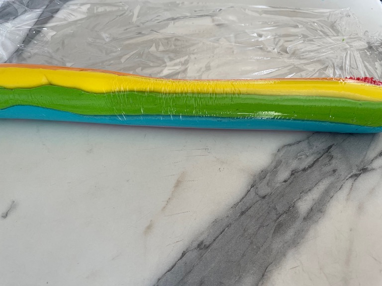 Clingfilm tube of rainbow buttercream