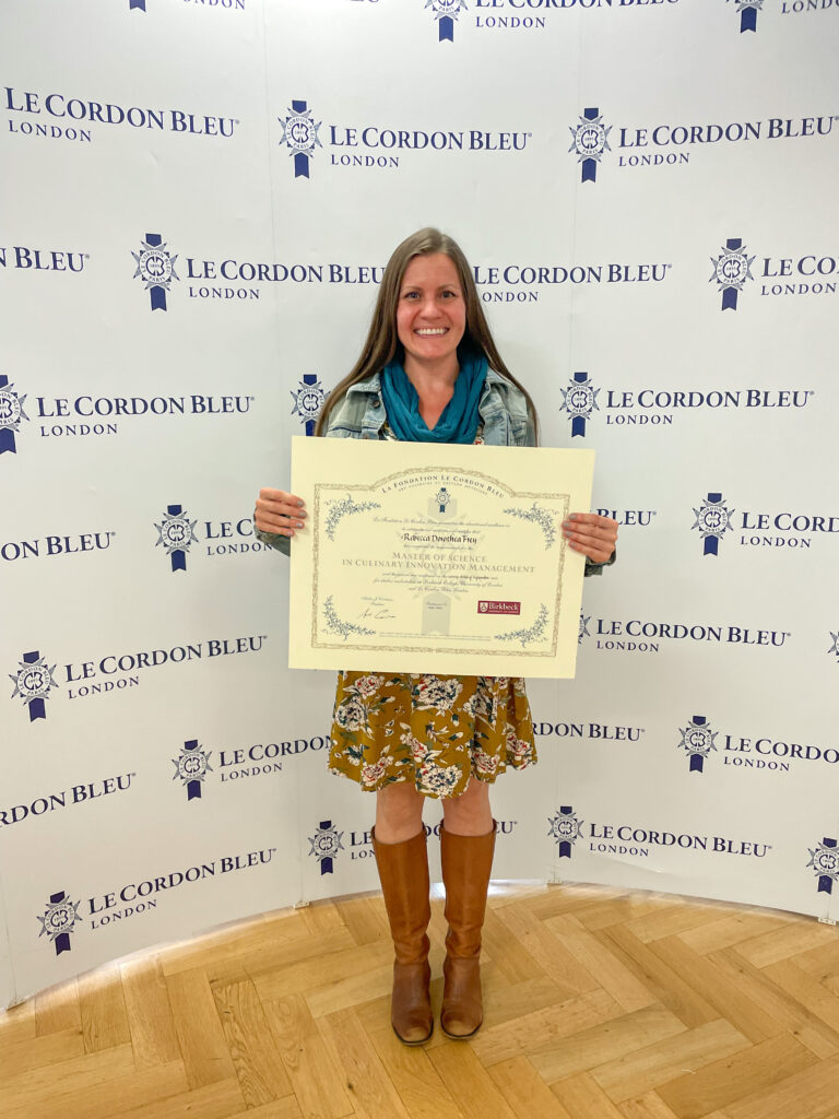 Rebecca Frey holding diploma from Le Cordon Bleu and Birkbeck